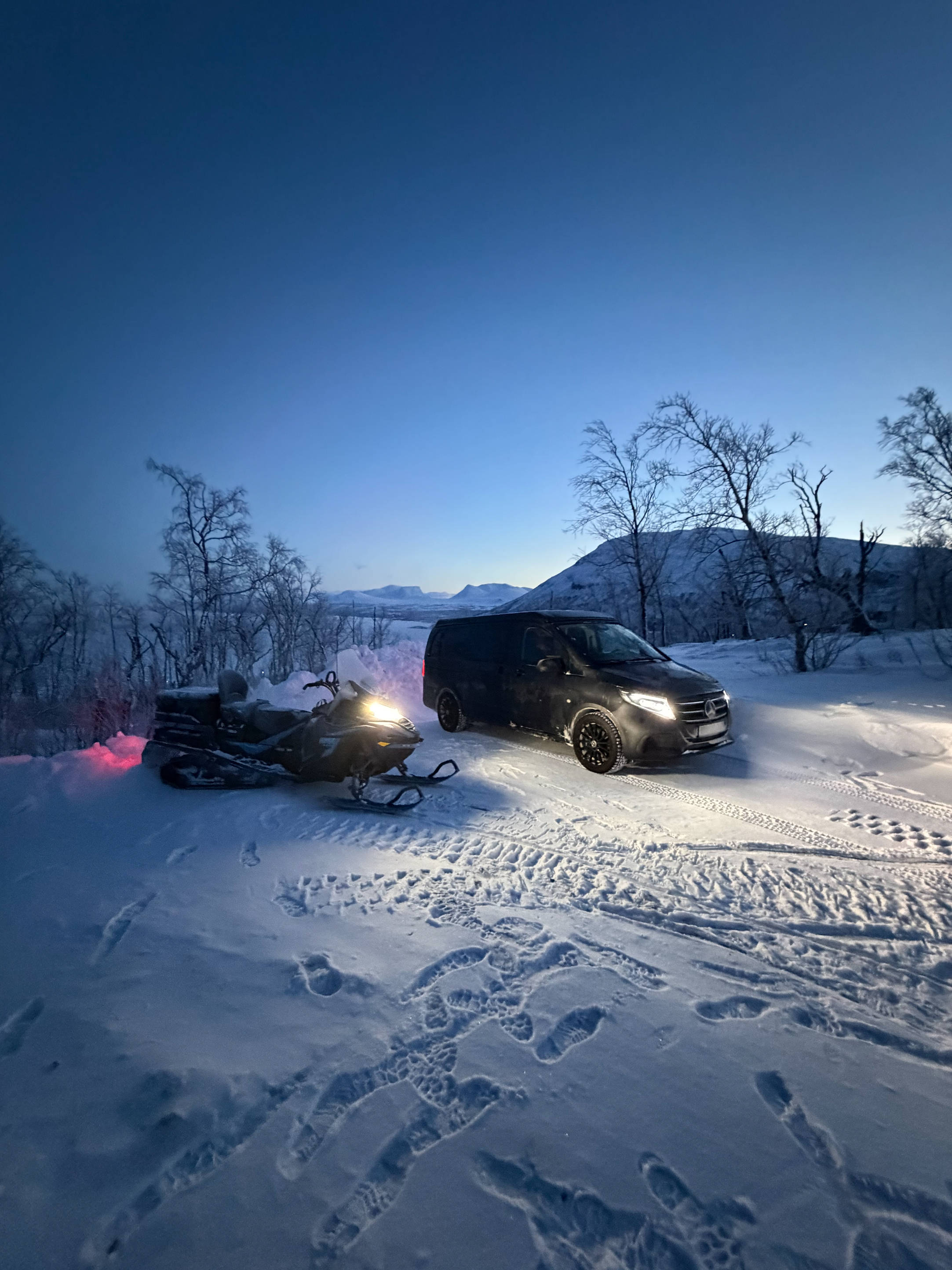 Offtrack Camper y moto de nieve en un paisaje nevado